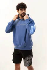 Canguro azul con capucha y bolsillo tipo canguro, estampado con texto en el frente.