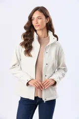 Campera de neopreno color blanco ocre, con calce entallado, cuello alto con capucha oculta y cierre frontal con cremallera y botones a presión. Cuenta con bolsillos laterales funcionales.