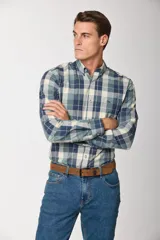 Camisa de manga larga con estampado de cuadros en tonos azules, grises y marrones. Presenta cuello abotonado, bolsillo frontal en el pecho y botones personalizados.