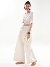 Pantalón palazzo color beige, de corte pescador y cintura alta con cordón ajustable.