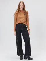 Polera de manga larga confeccionada en tela rib color bordó, con cuello alto y hombreras. Presenta costuras a la vista con pespuntes en hilo de color contrastante en el cuello, puños, hombros y ruedo.