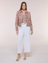 Chaqueta de tweed en tonos rosados, marrones y blancos, con hilos metalizados y lentejuelas brillantes. Presenta cuello camisero, cierre frontal con botones metálicos dorados, bolsillos frontales en el pecho, mangas largas y terminaciones desflecadas.