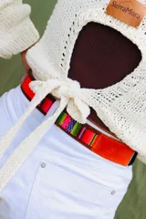 Cinturón de cuero marrón combinado con inserciones de gamuza, pelo vacuno y tejido tipo aguayo de colores. Cuenta con hebilla metálica rectangular envejecida.