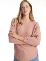 Buzo de punto rib color beige, con cuello redondo, manga japonesa tres cuartos y silueta relajada.
