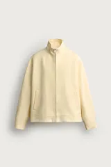 Cazadora regular fit de algodón color amarillo claro, con cuello alto, cierre frontal de cremallera y bolsillos de vivo en la cadera.