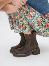 Bota tipo chelsea de cuero vacuno en color rojo con estampado floral grabado en negro. Presenta paneles laterales elásticos, suela de plataforma y taco cuadrado en color negro.