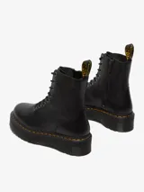 Botas negras de cuero con plataforma, cordones y costuras amarillas.