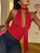 Top halter de color rojo, con escote profundo en V y lazada larga integrada al cuello. Confeccionado en tejido elástico y ajustado al cuerpo.