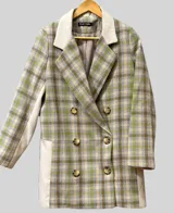 Tapado de corte recto con diseño a cuadros en tonos verde, beige y marrón. Presenta cuello con solapas anchas, cierre frontal cruzado con botones y mangas largas.