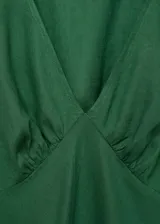 Vestido midi de tejido mezcla de lino y viscosa, color verde, con escote en pico drapeado, mangas cortas y diseño evasé.