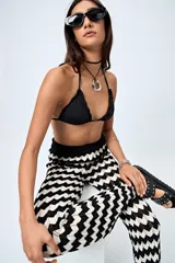 Top de bikini negro con tirantes finos y volados en el borde.