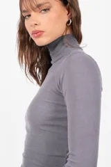 Top de morley gris de manga larga, con cuello media polera y largo de camiseta. Presenta un teñido en las terminaciones que crea un efecto degradado.