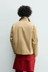 Sobrecamisa de corte relajado confeccionada en tejido de algodón con estructura canvas. Presenta cuello solapa, manga larga, cierre frontal con botones y dos bolsillos frontales de plastrón. Incluye un pequeño bordado a contraste en una de las mangas.