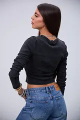 Remera negra de manga larga, con cuello redondo y tejido acanalado con efecto lavado.