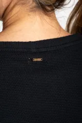 Sweater de algodón negro con calce oversize, cuello redondo y mangas largas con detalle de línea blanca lateral.