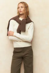 Polera color crema de tejido de punto con cuello redondo y mangas largas.