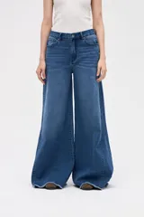 Jean de tiro medio con corte wide leg y diseño de pierna extra ancha. Presenta un lavado azul profundo y ruedo deshilachado.