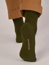 Medias de caña media en color verde oliva, confeccionadas en tejido de punto acanalado con el nombre de la marca estampado en la planta del pie.