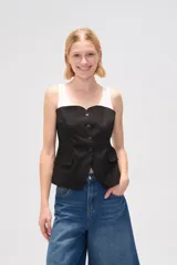 Top negro con breteles anchos, escote recto, cierre frontal con botones y bolsillos tipo parche.