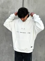 Canguro blanco con capucha ajustable con cordones, bolsillo tipo canguro y logo estampado en el pecho.