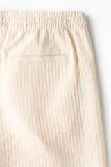 Short texturizado de mezcla de viscosa, color beige, con cintura elástica con cordón de ajuste y bolsillos laterales.