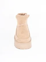 Bota corta tipo ugg con plataforma dentada, confeccionada en material gamuzado color beige con interior forrado en piel sintética.