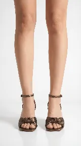 Sandalia de tacón medio ancho con diseño de nudo frontal y pulsera ajustable al tobillo con hebilla metálica.