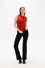 Chaleco de punto color rojo, con cuello polo y cierre frontal de botones. Diseño sin mangas y corte al cuerpo.