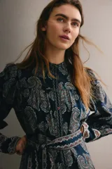 Vestido corto de estilo túnica en color azul marino con estampado paisley, cuello mao, mangas largas con puños anchos abotonados y un cinturón lazada ajustable a la cintura.