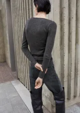 Remera de manga larga gris oscuro con cuello en V adornado con detalles de puntilla negra.