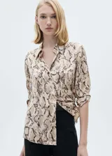 Camisa de tejido satinado fluido con estampado de serpiente, cuello camisero, cierre frontal de botones y manga larga.