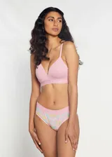 Conjunto de ropa interior compuesto por un soutien triangular liso en color rosado y una bombacha tipo culotte con estampado floral y detalles en tonos pasteles.