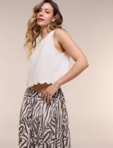 Falda larga de corte evasé con diseño estampado animal print estilo cebra en tonos beige y gris oscuro. Cuenta con tiro alto y pretina elástica fruncida.