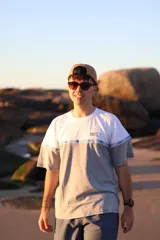 Remerón gris con mangas cortas y estampado frontal con el logo de la marca 'Glassy Waves' y un diseño de ondas y motivos tribales.