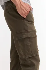 Pantalón tipo jogger cargo color verde militar, con bolsillos laterales con solapa, cintura elástica con cordón ajustable y puños elásticos en los tobillos.