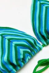 Traje de baño de dos piezas con estampado de rayas horizontales en tonos verde y celeste. El corpiño es de corte triangular con tirantes finos verdes y la bombacha es de corte clásico con tiras laterales verdes.