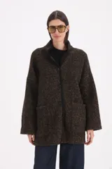 Saco 3/4 de tejido de punto texturizado en color marrón jaspeado, con cuello alto, cierre frontal de botones y bolsillos delanteros aplicados. Presenta detalles de ribetes en contraste a lo largo de la abertura frontal y el cuello.