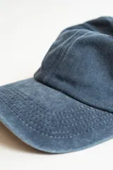 Gorra con visera de estilo clásico, confeccionada en tela con efecto desgastado.