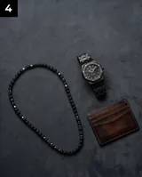 Collar de cuentas de piedra volcánica negra con detalles de eslabones cilíndricos de acero, diseño minimalista y masculino.