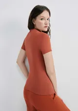 Camiseta verde claro de tela acanalada, con cuello alto y mangas cortas.