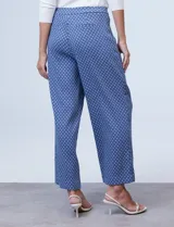 Pantalón de pierna amplia marca Zac & Rachel, confeccionado en tejido elastizado azul con estampado floral. Presenta bolsillos inclinados en la parte delantera, bolsillos simulados en la parte trasera, pretina con pasadores y botones.