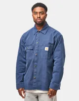 Sobrecamisa Carhartt WIP Parrish Shirt Jac de color azul, confeccionada en pana. Presenta cuello clásico, cierre frontal con botones metálicos a presión, dos bolsillos en el pecho con solapa y etiqueta con el logo de la marca.