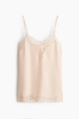 Top de satén color rosa claro, con escote en V pronunciado, breteles finos ajustables y detalles de encaje floral en el escote y en el ruedo.