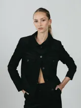 Campera de pana negra con cierre frontal de botones, cuello clásico y dos bolsillos delanteros con solapa.