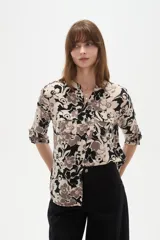 Camisa holgada de viscosa con cuello mao, mangas largas y estampado floral en tonos beige, marrón y negro, con dos bolsillos frontales con solapa.