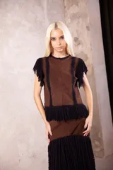 Falda larga de cuero marrón con diseño de capas y flecos largos de lana negra en la parte inferior.