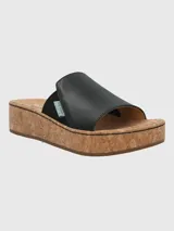 Sandalia tipo slide de Hush Puppies con capellada de cuero negro y banda elástica lateral. Presenta una suela de plataforma alta con acabado de corcho y base de caucho.