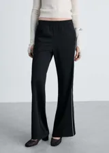 Pantalón de corte recto y tiro medio, color negro con detalle de raya lateral blanca en contraste. Cuenta con cintura elástica y bolsillos laterales.