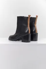Botas cortas de cuero negro con taco bloque y suela track.