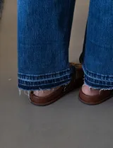 Jean de tiro alto y pierna ancha color azul, marca Royalty. Pretina con pasadores, cierre y botón. Delantera y trasera con bolsillos. Terminación de ruedo desflecado.